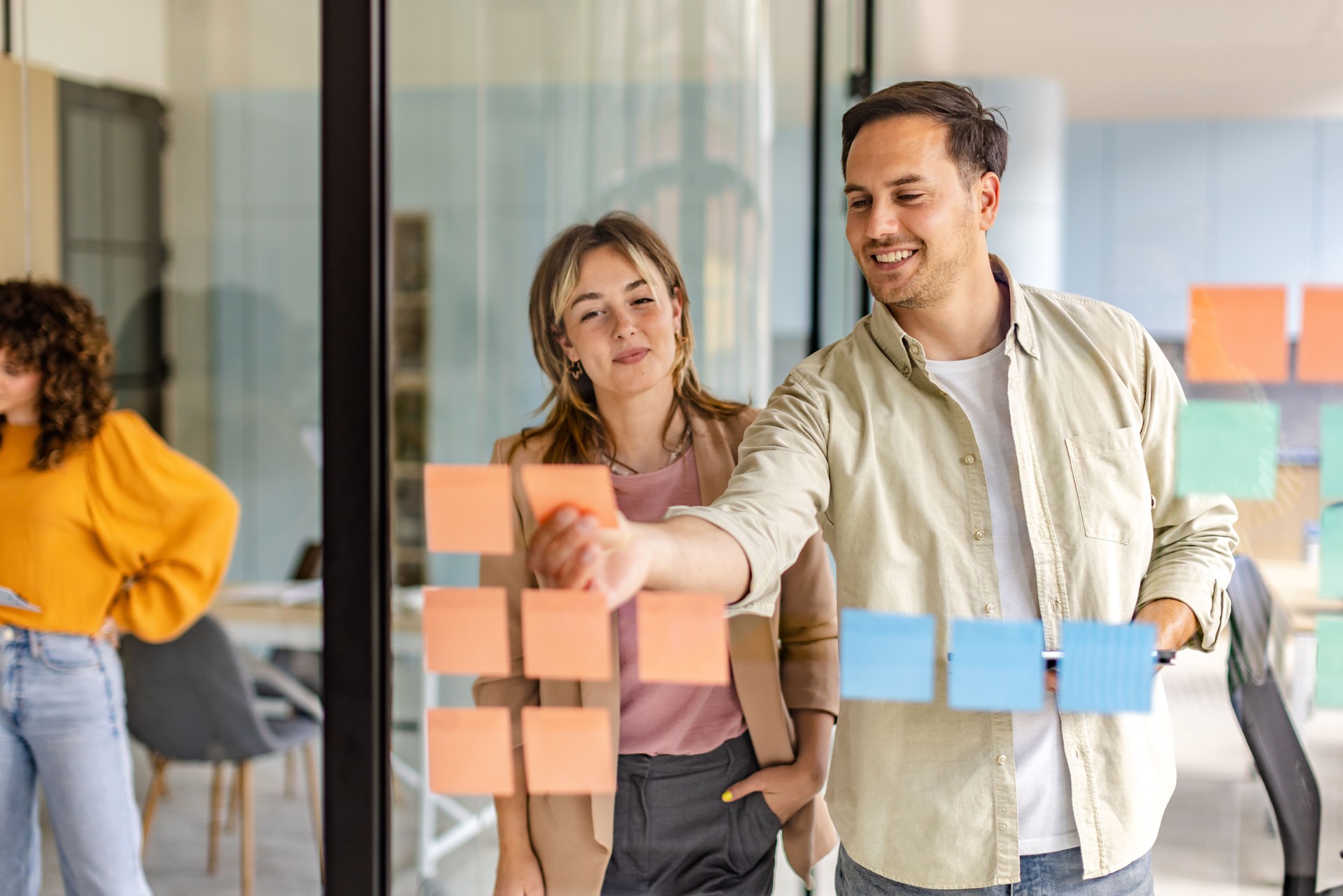Collaborative brainstorming session in modern office with diverse team members engaging with sticky notes